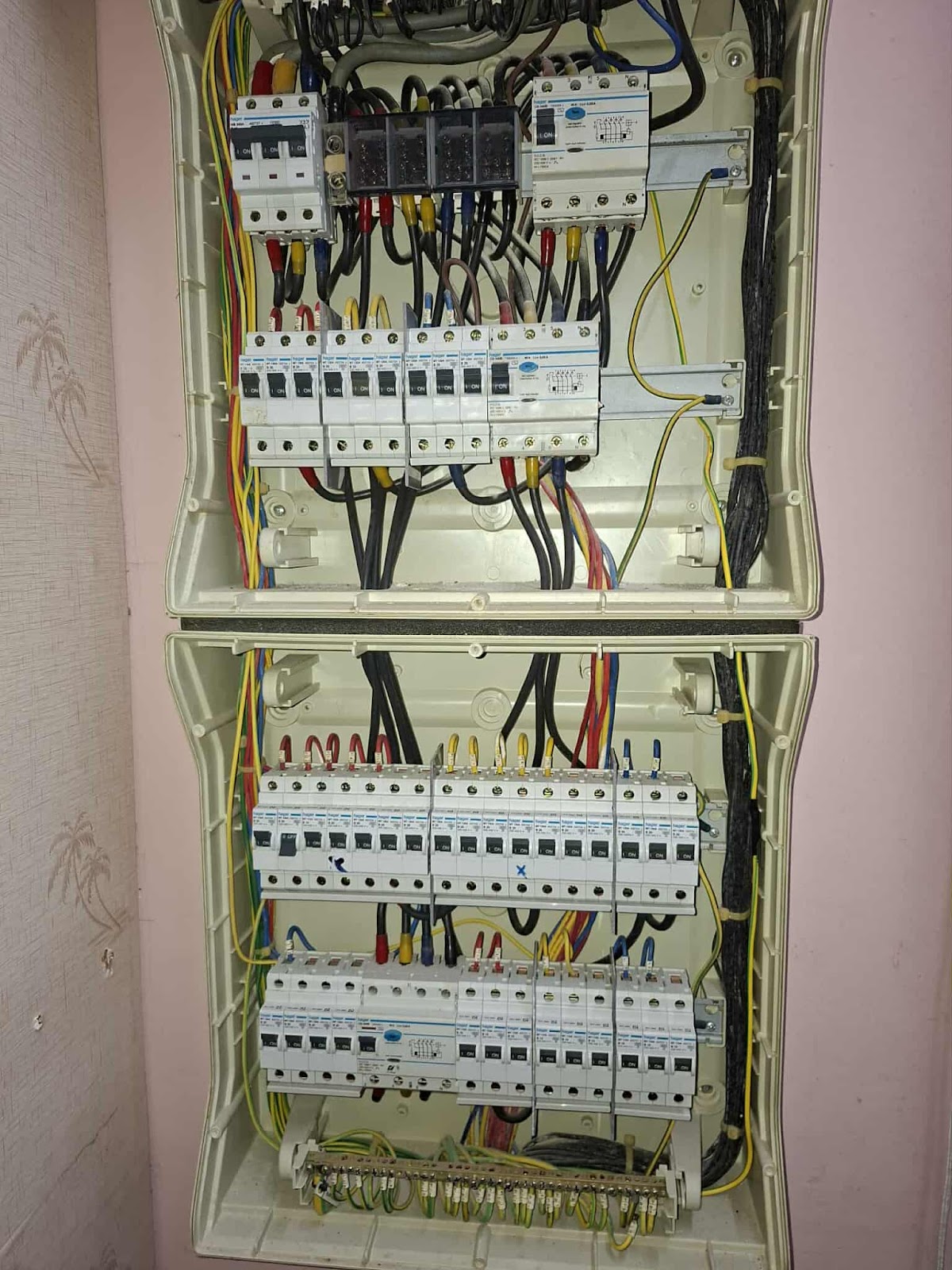 Two tier DB box open during rewiring, breakers and wiring exposed