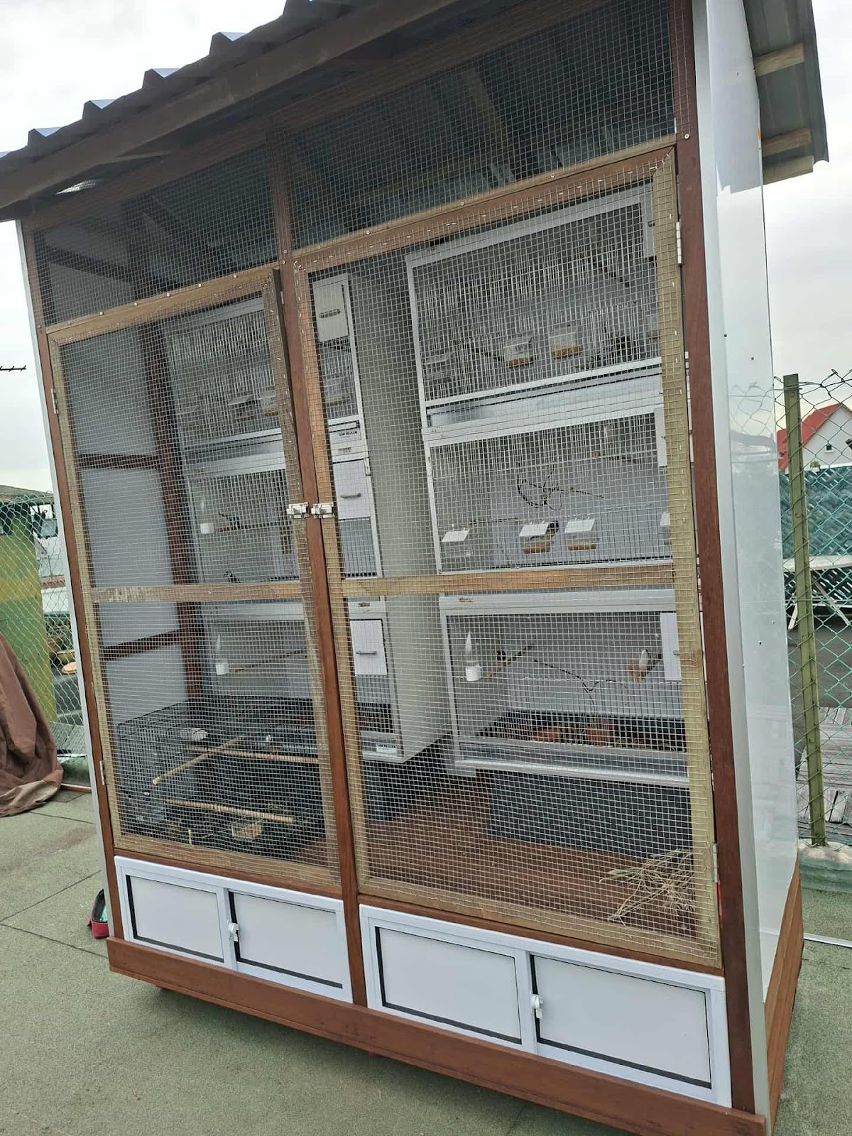 Finished large custom aviary with timber frame, mesh panels, pitched roof and built in cabinets